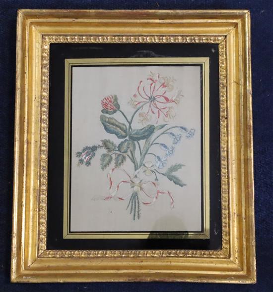 A pair of Regency silkwork panels of floral sprays, eglomise framed